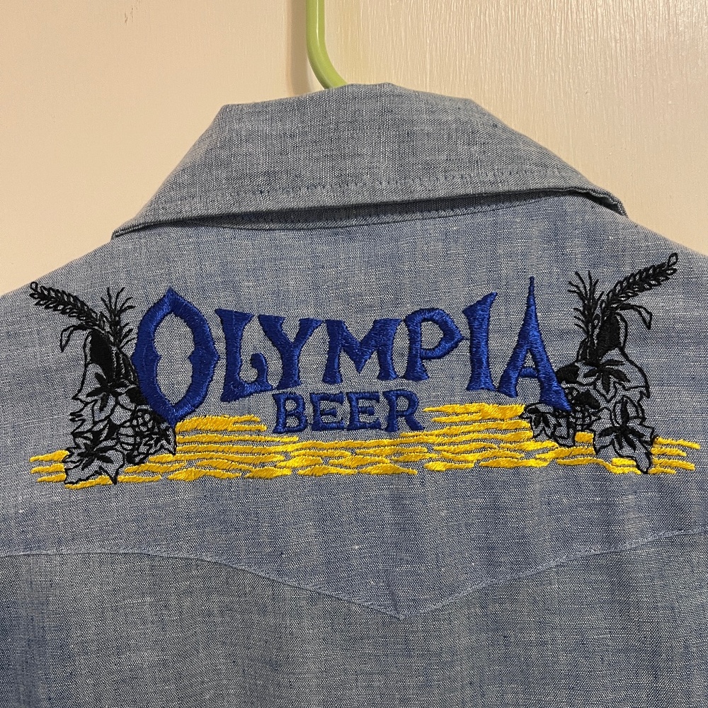 1970’s mint condition Beau Brummel Olympia Beer chambray shirt. Size Small
